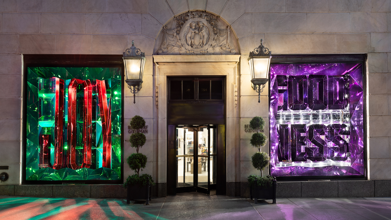 New York City, USA. 18th June, 2020. A reflection in Bergdorf Goodman  window of the newly opened (curbsidee pickup only) Louis Vuitton 5th Ave.  flagship store, decorated with a large rainbow in